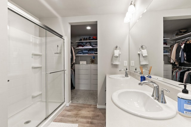 1225 E Paske Rd, Colbert, WA 99005 - bathroom featuring a walk in closet, wood finished floors, a stall shower, and double vanity