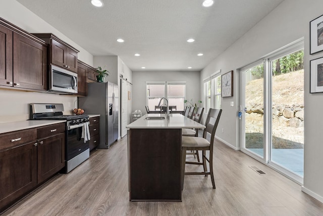 1225 E Paske Rd, Colbert, WA 99005 - kitchen featuring appliances with stainless steel finishes, a breakfast bar, recessed lighting, a center island with sink, and light countertops