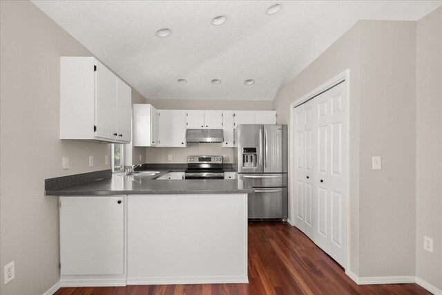 4407 E 14th Ave, Spokane, WA 99212 - kitchen featuring stainless steel appliances, under cabinet range hood, dark wood-style flooring, white cabinetry, and dark countertops