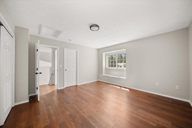 4407 E 14th Ave, Spokane, WA 99212 - unfurnished bedroom with attic access, wood finished floors, a closet, and a textured ceiling