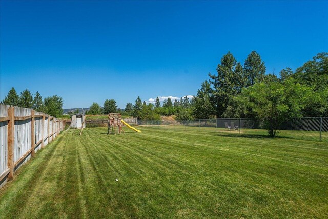 4407 E 14th Ave, Spokane, WA 99212 - fenced backyard with a playground and a shed