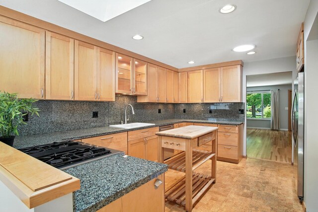 3121 S Manito Blvd, Spokane, WA 99203 - kitchen with light brown cabinetry, appliances with stainless steel finishes, recessed lighting, tasteful backsplash, and glass insert cabinets