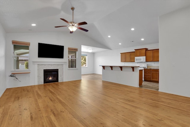 8812 W Pirates Ct, Spokane, WA 99224 - unfurnished living room featuring light wood-style flooring, lofted ceiling, a ceiling fan, a fireplace, and recessed lighting