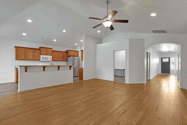 8812 W Pirates Ct, Spokane, WA 99224 - unfurnished living room featuring arched walkways, ceiling fan, light wood-style floors, recessed lighting, and high vaulted ceiling