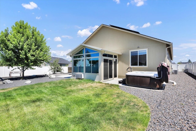 8812 W Pirates Ct, Spokane, WA 99224 - back of house featuring a hot tub, a sunroom, and a fenced backyard