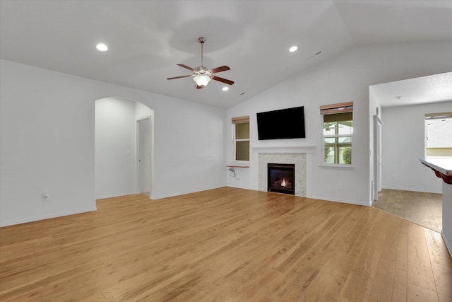 8812 W Pirates Ct, Spokane, WA 99224 - unfurnished living room featuring ceiling fan, a tiled fireplace, light wood finished floors, arched walkways, and recessed lighting