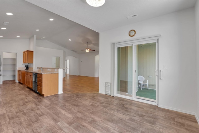 8812 W Pirates Ct, Spokane, WA 99224 - kitchen featuring arched walkways, dishwashing machine, open floor plan, vaulted ceiling, and light wood-type flooring