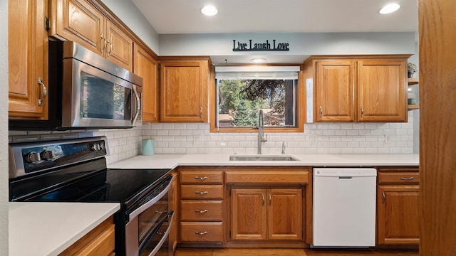 811 W Teal Ave, Spokane, WA 99218 - kitchen with appliances with stainless steel finishes, brown cabinetry, light countertops, backsplash, and recessed lighting