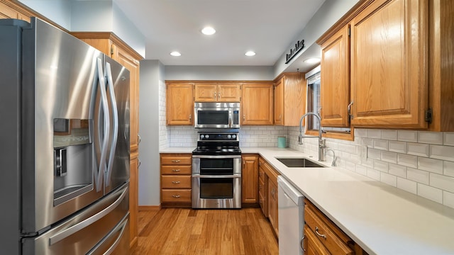 811 W Teal Ave, Spokane, WA 99218 - kitchen featuring stainless steel appliances, light wood-style floors, light countertops, brown cabinetry, and recessed lighting