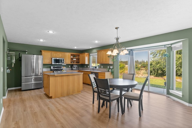 3421 S Mcdonald St, Spokane Valley, WA 99206 - kitchen with stainless steel appliances, open shelves, a chandelier, a center island, and light wood finished floors