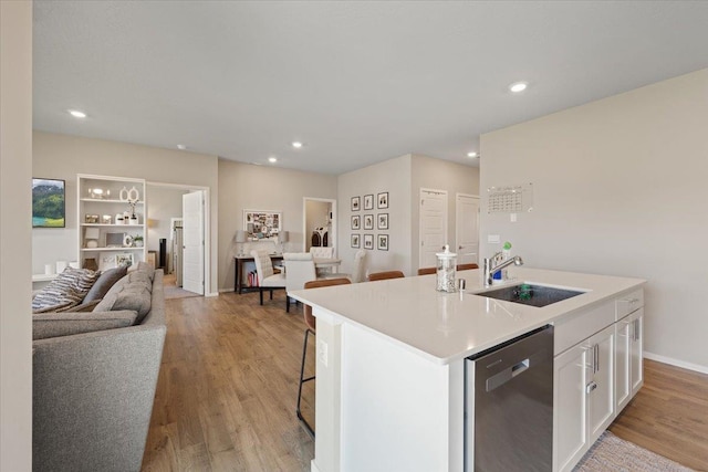 8403 W Red Ave, Cheney, WA 99004 - kitchen featuring stainless steel dishwasher, open floor plan, white cabinets, recessed lighting, and a center island with sink
