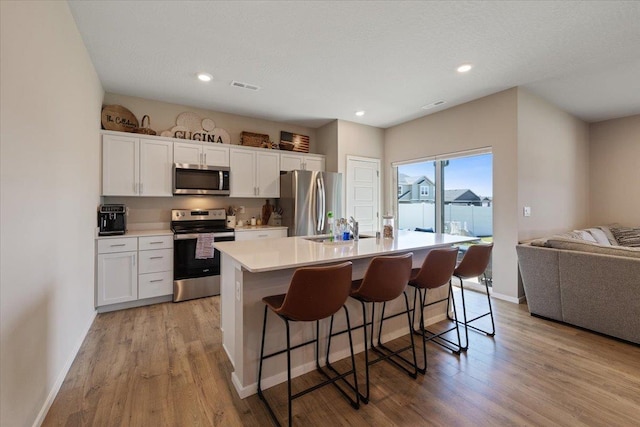 8403 W Red Ave, Cheney, WA 99004 - kitchen with stainless steel appliances, light wood-type flooring, a center island with sink, open floor plan, and recessed lighting