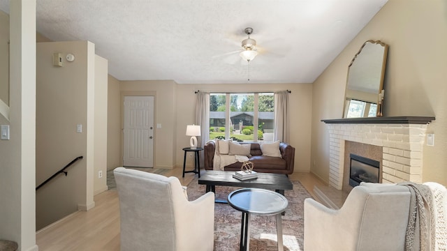 5623 W Lyons Ct, Spokane, WA 99208 - living area with light wood finished floors, a ceiling fan, and a brick fireplace