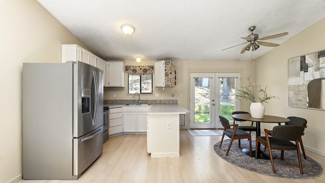 5623 W Lyons Ct, Spokane, WA 99208 - kitchen featuring stainless steel fridge, white cabinetry, light wood finished floors, a ceiling fan, and vaulted ceiling