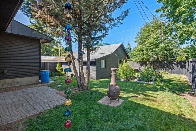 3129 E 34th Ave, Spokane, WA 99223 - fenced backyard with a vegetable garden, an outbuilding, and a patio area