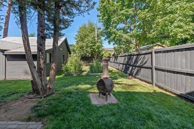 3129 E 34th Ave, Spokane, WA 99223 - fenced backyard with a vegetable garden and an outdoor fire pit