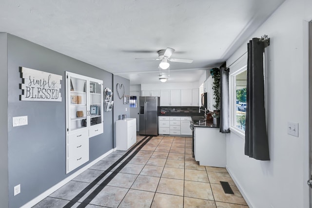 5917 N Addison St, Spokane, WA 99208 - kitchen featuring stainless steel appliances, dark countertops, white cabinetry, light tile patterned floors, and ceiling fan