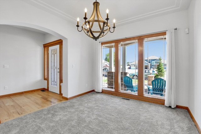 2312 W Abigail Ct, Spokane, WA 99208 - spare room featuring a chandelier, arched walkways, and carpet flooring