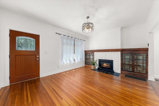 1728 S Adams St, Spokane, WA 99203 - unfurnished living room with wood finished floors, a chandelier, ornamental molding, and a brick fireplace