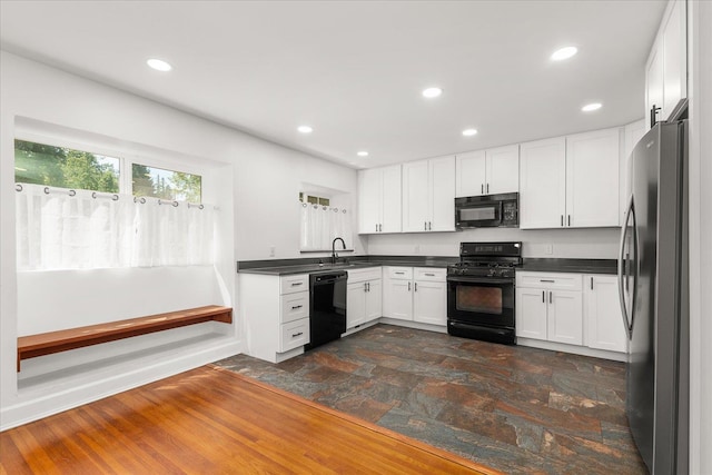 1728 S Adams St, Spokane, WA 99203 - kitchen with black appliances, dark countertops, white cabinets, dark stone finish floors, and recessed lighting