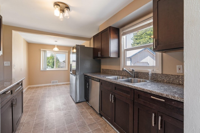4615 N King Ct, Spokane, WA 99205 - kitchen featuring appliances with stainless steel finishes, dark brown cabinetry, dark countertops, and decorative light fixtures