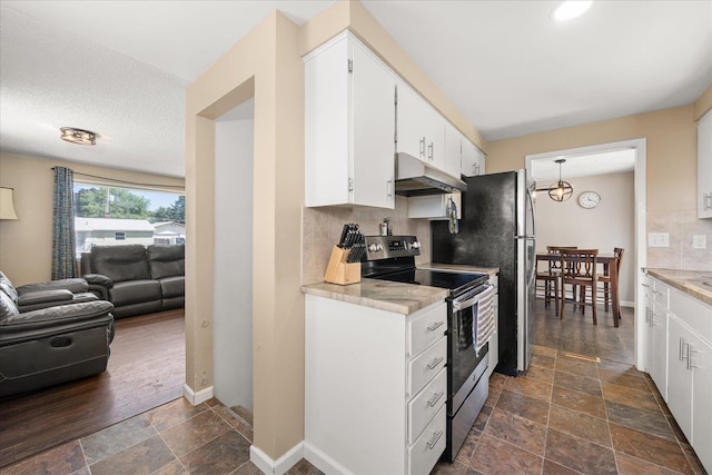 1634 E Dalke Ave, Spokane, WA 99208 - kitchen featuring electric stove, under cabinet range hood, stone tile flooring, backsplash, and open floor plan