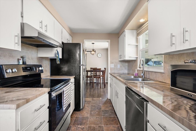 1634 E Dalke Ave, Spokane, WA 99208 - kitchen with stainless steel appliances, under cabinet range hood, tasteful backsplash, and white cabinets