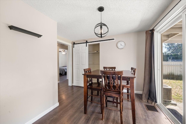 1634 E Dalke Ave, Spokane, WA 99208 - dining area featuring a barn door, a textured ceiling, and dark wood-style floors