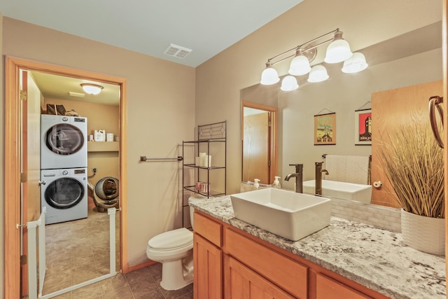 12837 E 37th Ln, Spokane Valley, WA 99206 - bathroom featuring stacked washer / dryer, vanity, and tile patterned flooring
