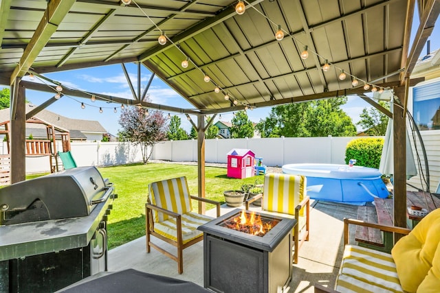 12837 E 37th Ln, Spokane Valley, WA 99206 - fenced backyard with a fire pit, a patio, a playground, and a hot tub