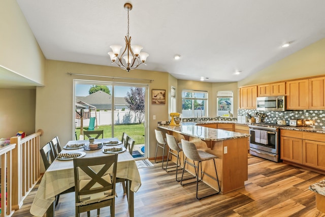 12837 E 37th Ln, Spokane Valley, WA 99206 - kitchen with stainless steel appliances, a peninsula, light stone countertops, backsplash, and a breakfast bar