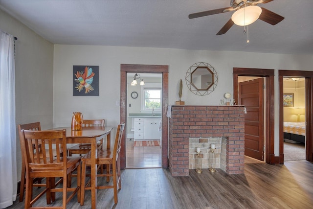 4028 N Post St, Spokane, WA 99205 - dining room featuring wood finished floors, a ceiling fan, and a brick fireplace