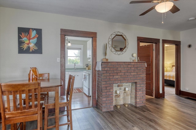 4028 N Post St, Spokane, WA 99205 - dining room with wood finished floors, a brick fireplace, and a ceiling fan