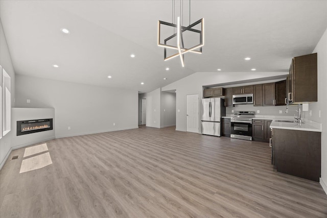 2912 E Wabash Ave, Spokane, WA 99217 - unfurnished living room featuring lofted ceiling, light wood-style flooring, recessed lighting, and a glass covered fireplace