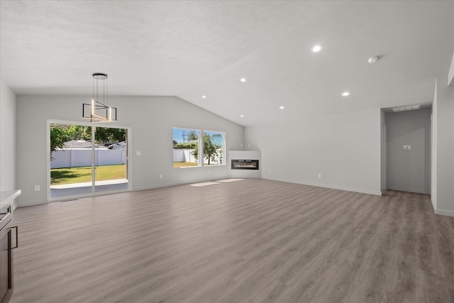2912 E Wabash Ave, Spokane, WA 99217 - unfurnished living room featuring a glass covered fireplace, lofted ceiling, light wood-style flooring, and recessed lighting
