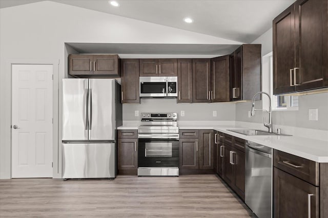 2912 E Wabash Ave, Spokane, WA 99217 - kitchen with stainless steel appliances, vaulted ceiling, dark brown cabinetry, light countertops, and recessed lighting