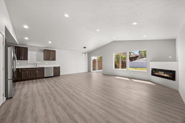 2912 E Wabash Ave, Spokane, WA 99217 - unfurnished living room featuring lofted ceiling, light wood-style flooring, a glass covered fireplace, and recessed lighting