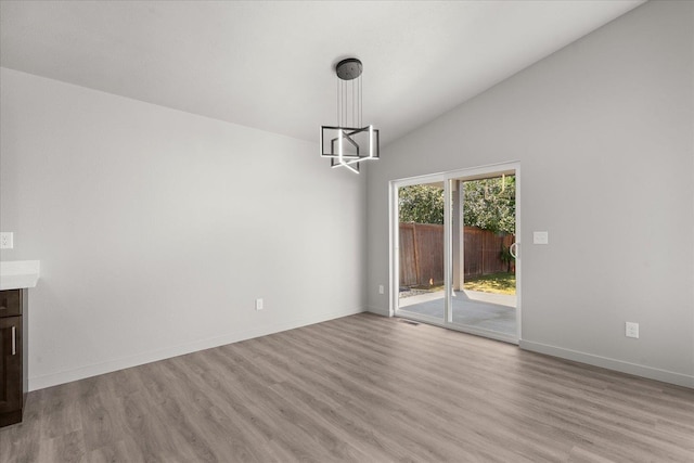 2912 E Wabash Ave, Spokane, WA 99217 - unfurnished dining area with a chandelier, light wood finished floors, and vaulted ceiling