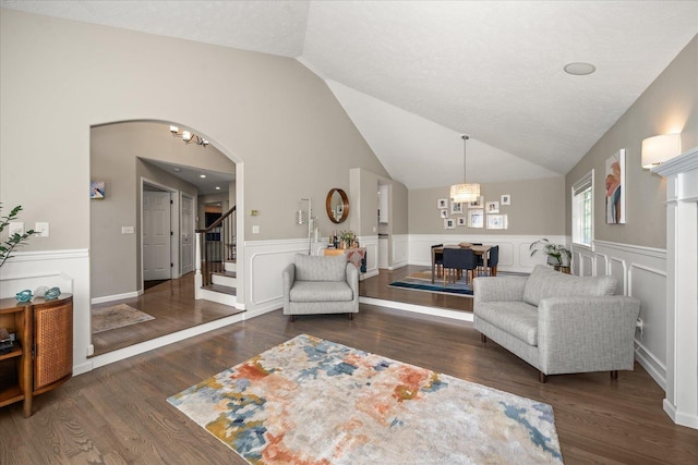 5203 S S Hogan Ct, Spokane, WA 99223 - living room featuring a wainscoted wall, lofted ceiling, arched walkways, stairway, and wood finished floors