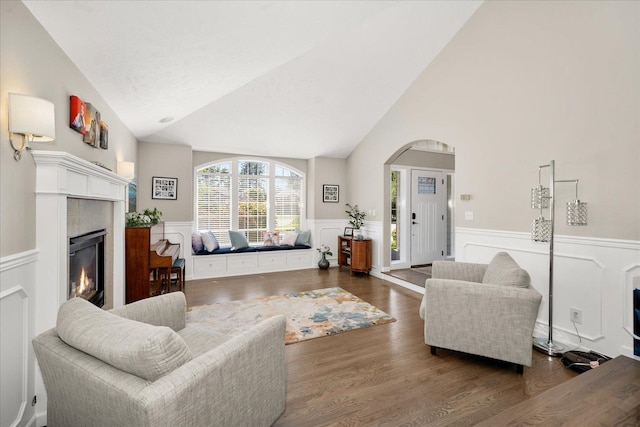 5203 S S Hogan Ct, Spokane, WA 99223 - living area featuring a fireplace, wood finished floors, wainscoting, arched walkways, and high vaulted ceiling
