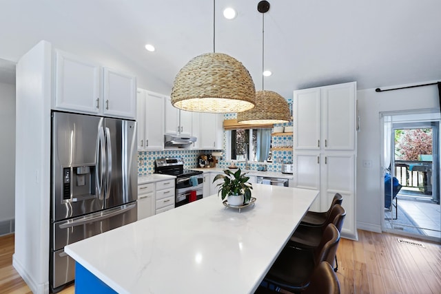 18017 N Lidgerwood Ct, Colbert, WA 99005 - kitchen with stainless steel appliances, white cabinets, decorative backsplash, light wood finished floors, and a center island