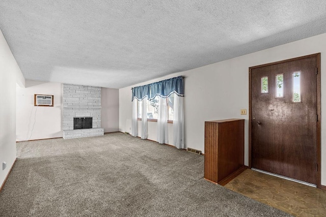 11622 E 24th Ave, Spokane Valley, WA 99206 - unfurnished living room with a textured ceiling, plenty of natural light, a fireplace, carpet floors, and a wall mounted AC