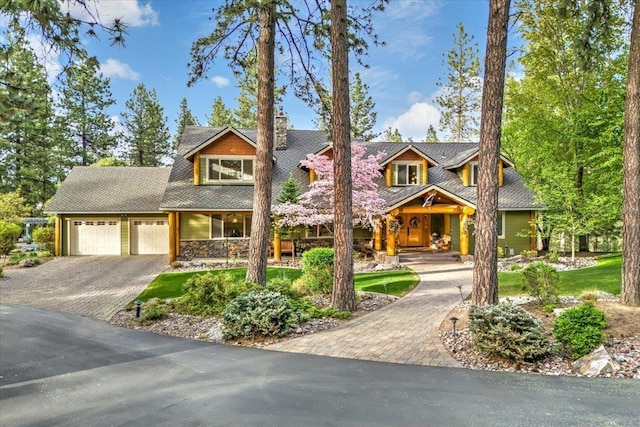 3222 S Conklin Rd, Greenacres, WA 99016 - view of front of property with driveway, an attached garage, a porch, stone siding, and a chimney