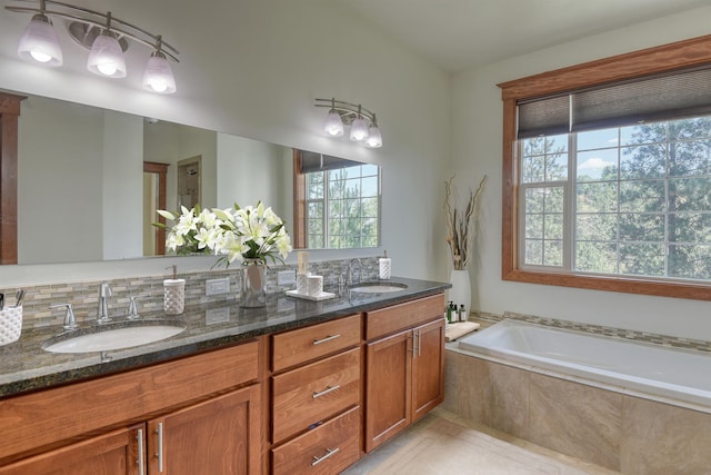 7302 N Quamish Dr, Spokane, WA 99208 - full bathroom featuring double vanity, a bath, tile patterned floors, and decorative backsplash