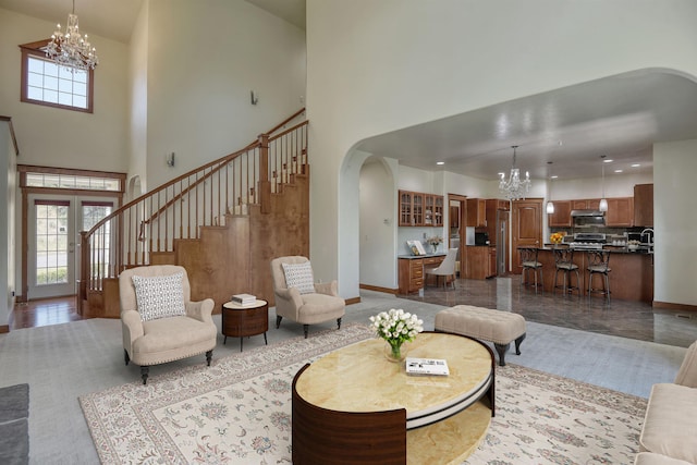7302 N Quamish Dr, Spokane, WA 99208 - living room featuring a chandelier, arched walkways, a high ceiling, and stairs