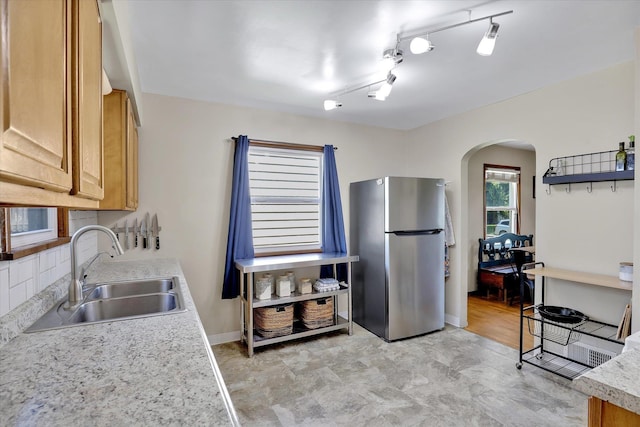 3526 W Hoffman Ave, Spokane, WA 99205 - kitchen with freestanding refrigerator, arched walkways, light countertops, and brown cabinetry