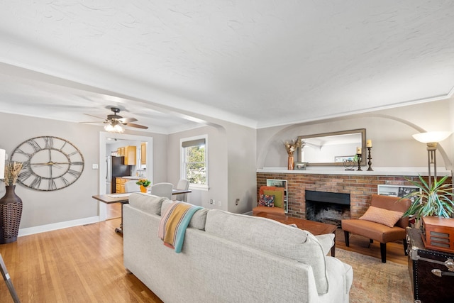 617 E 34th Ave, Spokane, WA 99203 - living area with light wood-style flooring, a brick fireplace, and ceiling fan