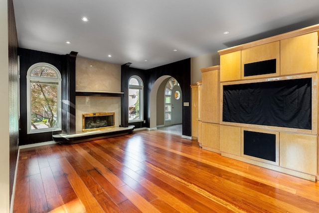 2010 E Pinecrest Rd, Spokane, WA 99203 - unfurnished living room featuring arched walkways, a fireplace, hardwood / wood-style flooring, and recessed lighting