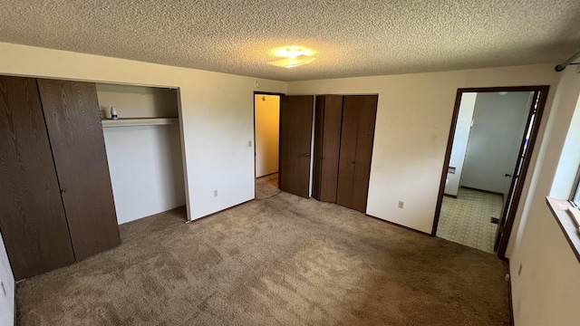 3520 N Arden Rd, Otis Orchards, WA 99027 - unfurnished bedroom with multiple closets, carpet floors, and a textured ceiling
