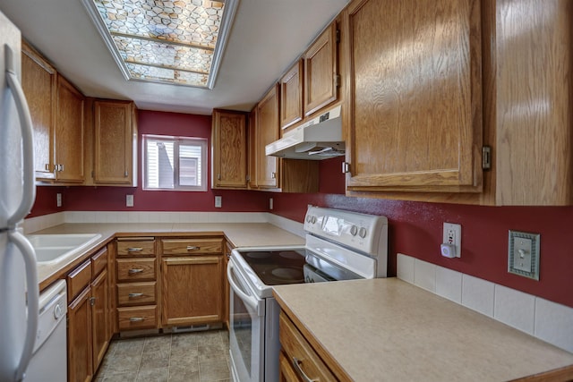 3222 W 4th Ave, Spokane, WA 99224 - kitchen featuring white appliances, under cabinet range hood, brown cabinets, and light countertops